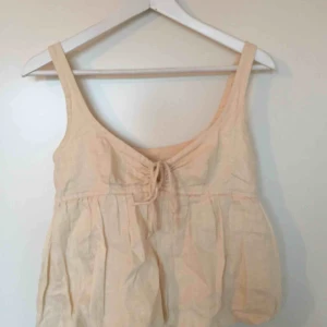  - Jättefin naturvit topp i 100% linne från Kookai. Fint skick och detaljer som gör den unik. Knäpps med knappar på sidan. Möts upp i Stockholm efter överenskommelse eller skickas mot fraktkostnad.