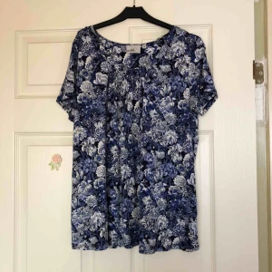  - Söt blommig topp i blå/vit. Frakt 19 kr🌿