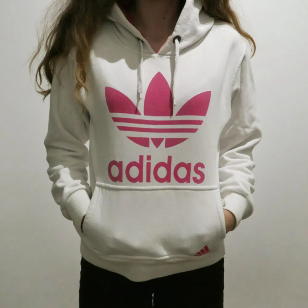 Snygg hoodie från Adidas! Vit hoodie med rosa Adidas tryck. Använd enstaka gånger. Väldigt bra skick. Köparen står för frakten. Tar bara swish! Hör av dig vid intresse eller om du har några frågor💜. Hoodies.