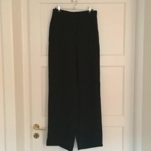  - Helt oanvända skitsnygga byxor från Monki i kostym tyg! Höga i midjan och vida i benen! Aldrig använda, tags kvar! Köparen står för frakt.