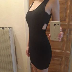  - Tight klänning i "scuba"-material
Lite insydd i midjan
Hål på vardera sida om midjan(bild2)