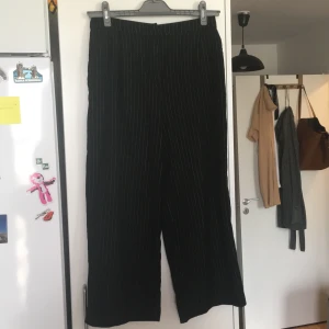 Svarta kostymbyxor med vita räder stl 36 - Kostymbyxor med korta ben, (perfekt för den som är lite kortare) väldigt bekväma och funkar lika väl till en chill kväll men kompisarna som en mer ordentlig tillställning. 