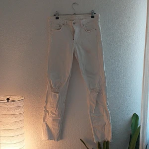 Vita jeans med slitningar - Slitningar på knän och benslut, liten fläck på vänsterficka bak. Använda 2 ggr. 