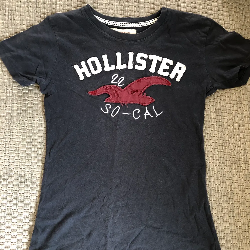(GRATIS FRAKT) Marinblå t-shirt från Hollister i fint skick! Storlek L i BARNSTORLEK, passar en XS då den är väldigt liten i storleken.. T-shirts.