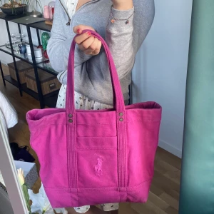 Ralph Lauren strandväska/väska - Jättesnygg praktisk Ralph Lauren Väska i en härlig rosa/lila färg. Passar perfekt att lägga ner strandhanduken till stranden i men även till övernattningsväska. 