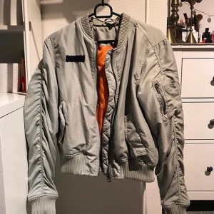 Bomberjacka  - Bomberjacka i ljusblå/grå färg med orange på insidan