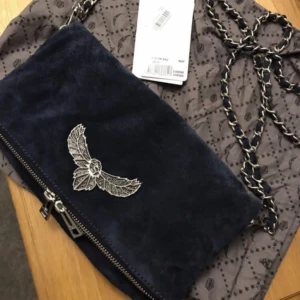  - Säljer en ny och oanvänd Zadig & Voltaire rock clutch. Är i mocka med en stor logga på framsidan. Köptes på nypris för ca 3500kr. Somsagt är den helt ny och prisalappen sitter till och med kvar! 2 kedjor tillkommer, en lite längre så att den kan användas som en crossbodybag och en till så att den kan användas som en liten väska!