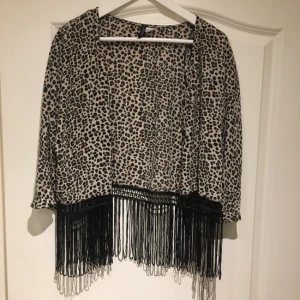  - Leopardmönstrad, tunn kofta med fransar. Knäppning fram om man vill. Strl 38.