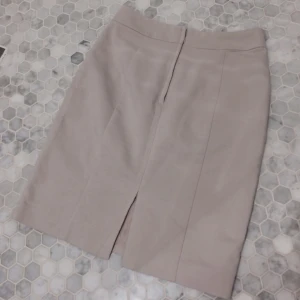  - Ljus beige kjol, knälång. I väldigt bra skick.