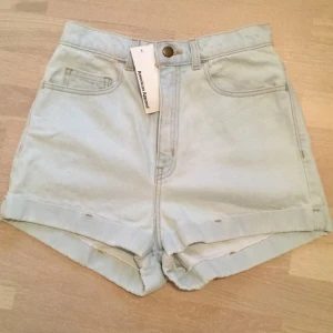  - Klassiska jeansshorts med hög midja. Aldrig använda. Rätt små i storleken. Passar en S och XS.  
Köparen står för frakten.