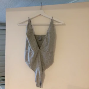  - Grå bodysuit med fin urringning, köpt för ett antal år sedan men har sällan kommit till användning.   Finns att hämta upp i Stockholm alternativt fraktas mot en fraktkostnad. Från ett djur och rök-fritt hem.