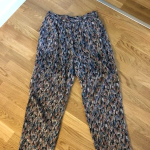  - Made in the shade. Underbart lös sittande långbyxor med fjädermotiv. Pris inklusive fakt! 