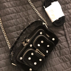 NuNoo svart mocka väska - Coolaste HELT NYA väskan från NuNoo i svart mocka med diamanter på. Har alldeles för många väskor för tillfället som jag inte använder, så bättre att sälja till någon annan 💓 Originalpriset är 1400kr 