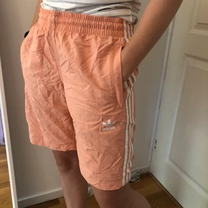 Badbyxor från Adidas, storlek M - Aprikosfärgade badbyxor från adidas som passar både tjejer och killar.