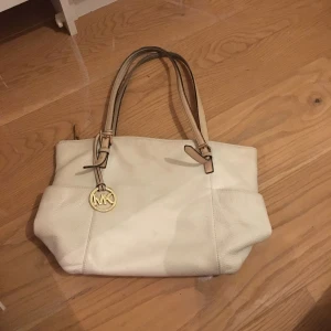  -  JET SET EAST WEST TOP ZIP VANILLA LARGE TOTE  Fick i present för 6år sedan, använde den rätt mycket i början men har nu legat i grderoben länge. Vill hellre sälja billigt istället för att slänga den.  JET SET EAST WEST TOP ZIP VANILLA LARGE TOTE i färgen Vanilla (ljus beige)