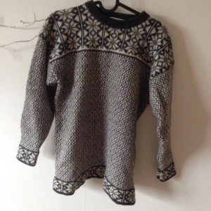  - Mysig stickad ylletröja i klassiskt mönster. Tightare längs ner i ärmen, höftkort! Ganska hög i halsen. 