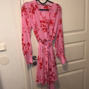 Sommarklänning från bikbok - Fin klänning från bikbok med blommor på. Fina detaljer med knappar i ärmen. Samt ett vant i midjan. Använd en gång! Står inte för frakten😊