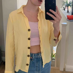  - Jättefin ljusgul skjorta med brun/svarta knappar. Jättefint skick o lent materia. Speciellt fin nu till våren/sommaren när man är lite solbränd. Funkar både som skjorta och som ”kofta” att ha över nån topp. Frakt tillkommer!