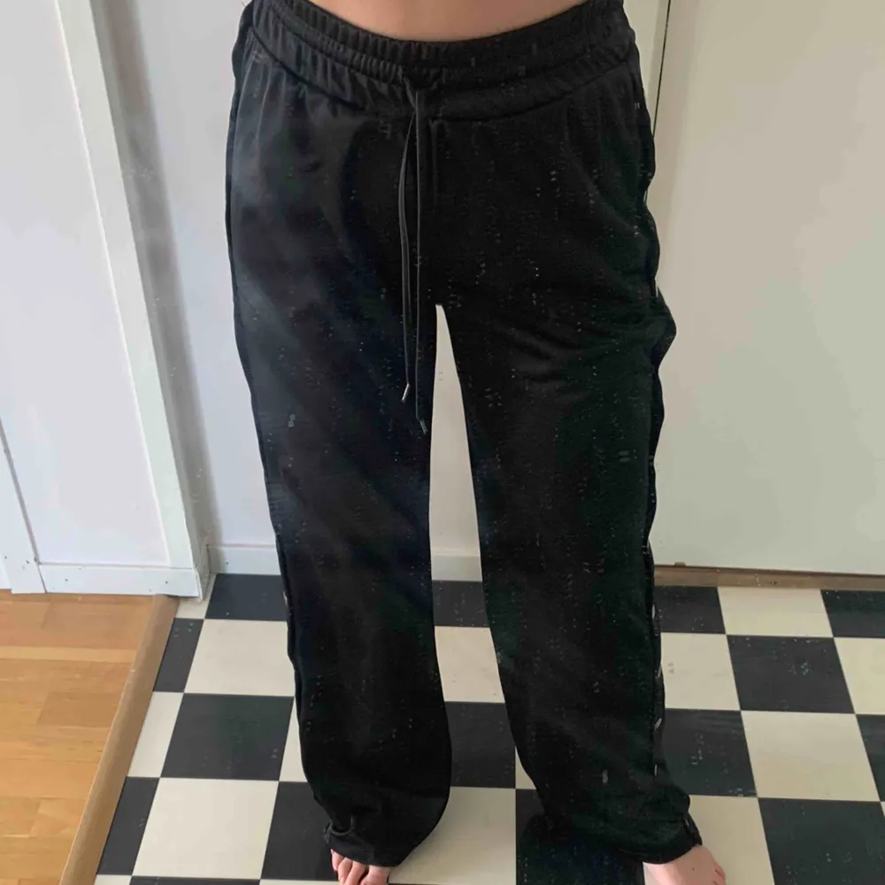 Snygga byxor/trackpants i glansigt tyg från chiquelle, knappt använda, knappar på sidorna som går att knäppa upp hela vägen :) 63kr frakt tillkommer!. Jeans & Byxor.