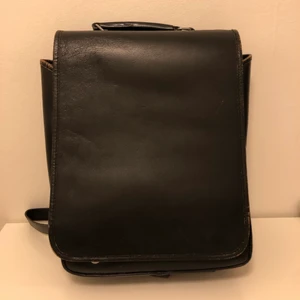 Ryggsäck i läder - En fin svart läderväska från Indiska som är inköpt på second hand. Den är lite nött på kanterna, vilket gör att den får en snygg vintage-look. Mått: 30x38x10 