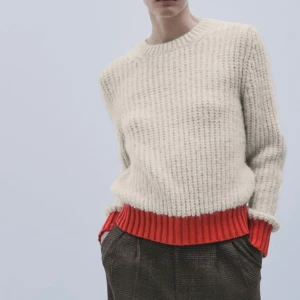 Tröja med röda detaljer  - Super snygg tröja, helt oanvänd så det är som ny. Säljer då jag helt enkelt inte fått använding för den. Helt slutsåld i butik och på hemsidan. Frakt 65kr.