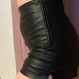 Svarta läder shorts från HM med slits och dragkedja på sidorna. Storlek: 36 Pris: 50kr +frakt