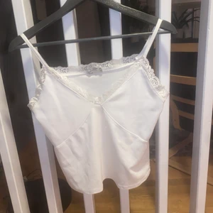 Linne/topp från Nelly  - Vitt linne med spets från Nelly, väldigt fint skick. Storlek Xs
