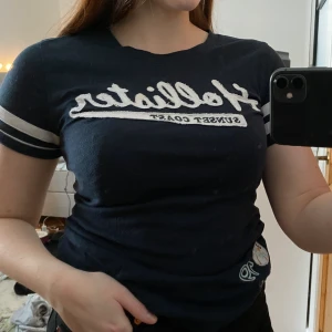 Marinblå Hollister T-shirt - Väldigt skön och fin tisha från Hollister som är köpt i London. Använd och lite nopprig men fortfarande väldigt skön. 