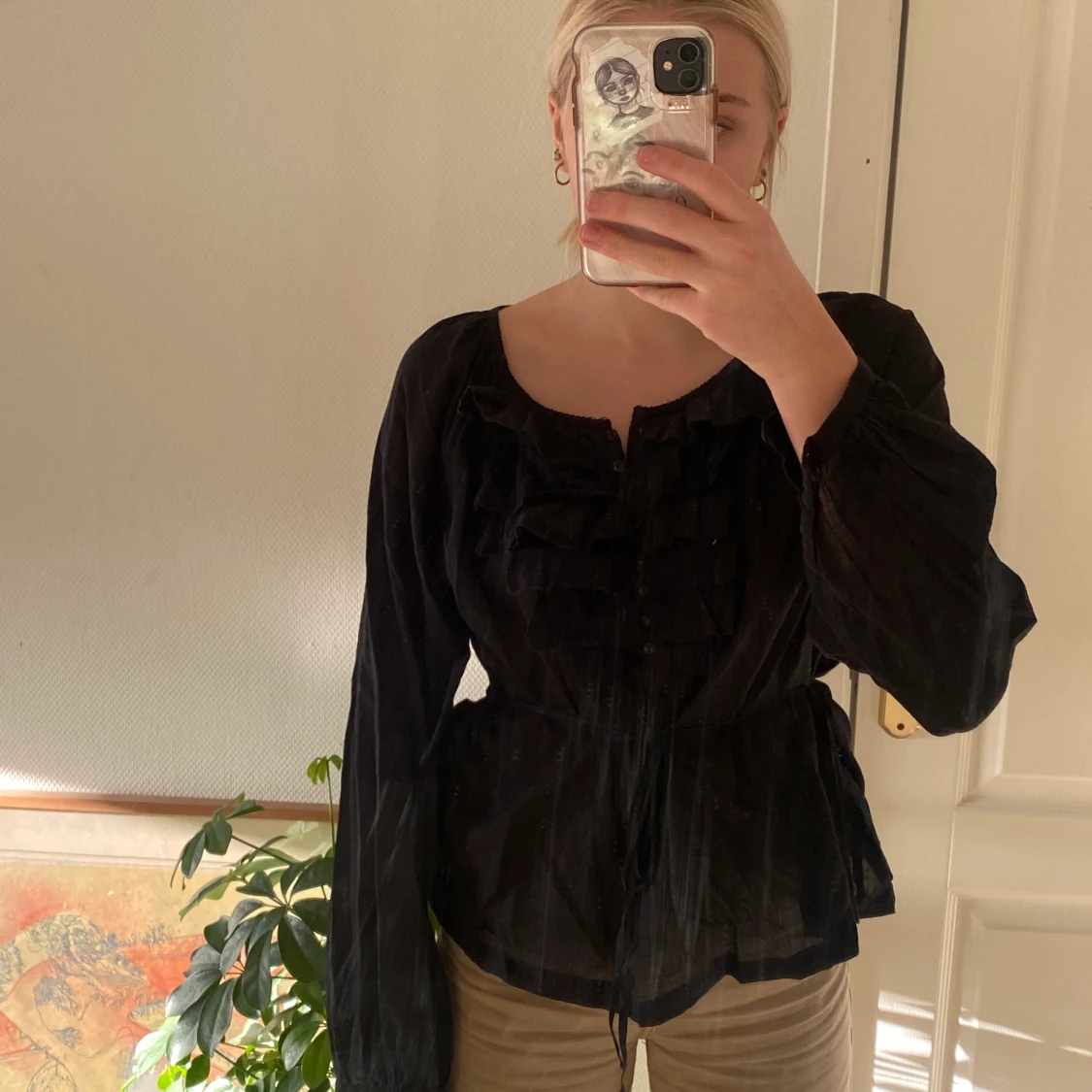 Svart blus med volanger och knytning