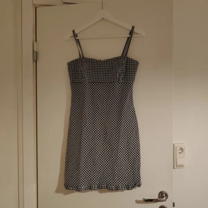 Rutig kortklänning - En rutig klänning från märket Pourquoi Pas. Dragkedja i ryggen. 