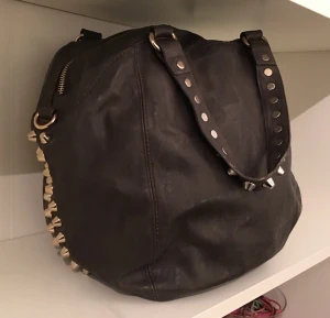  - Mörkbrun handväska från Gina med guldiga nitar!