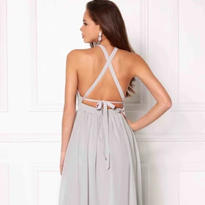  - Säljer exakt en sådan här från Bubbleroom. Den är ljus grå och band som korsar i ryggen, man justerar banden hur man vill. Inga inlägg. Den är lång och går till lite över fötterna (på mig som är 170). Använt den endast en gång på ett bröllop! Som ny!