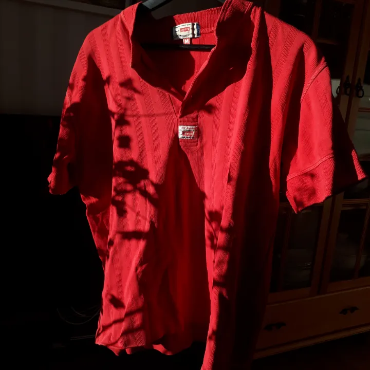 Röd vintage Levi's t-shirt med knappar, två av knapparna är borta men det är inget som stör. Det är lätt att sy dit två nya om man vill. . T-shirts.