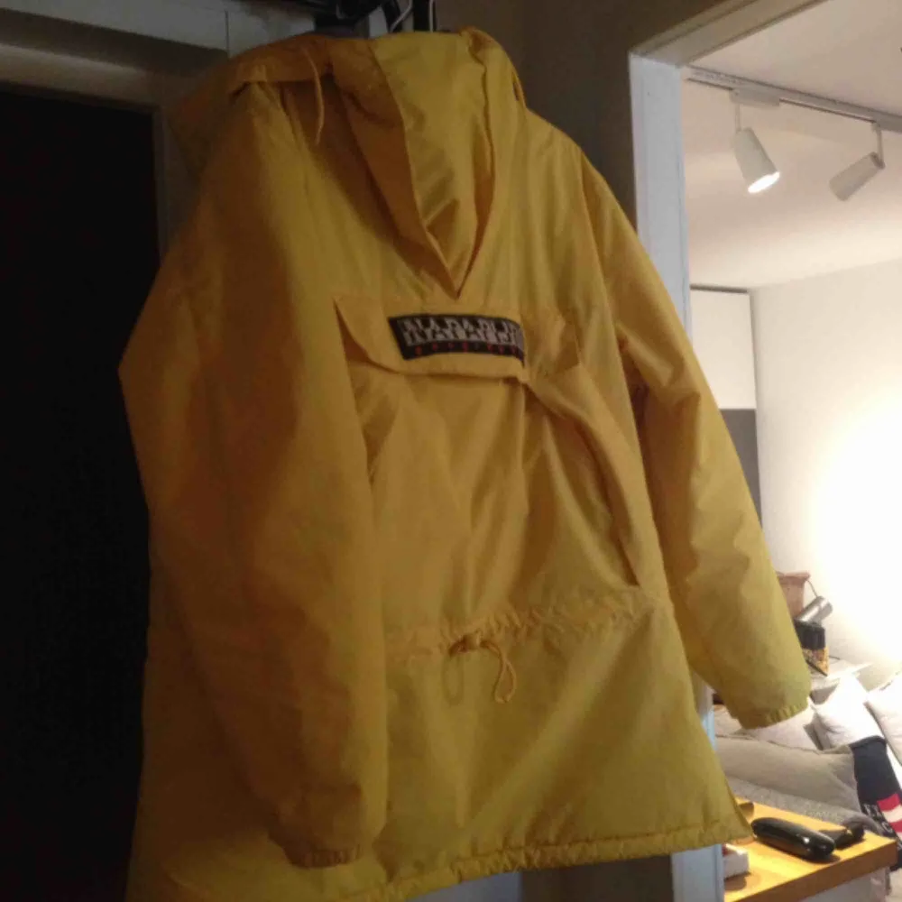 En napaijir jacka gul är mycket varm och skön i minus grader , fryser inte i den , har en öppning på sida. Och en luva samt en fixa i mitten av jackan köpt för ett år sedan är i mycket bra skick nypris 3100kr . Jackor.