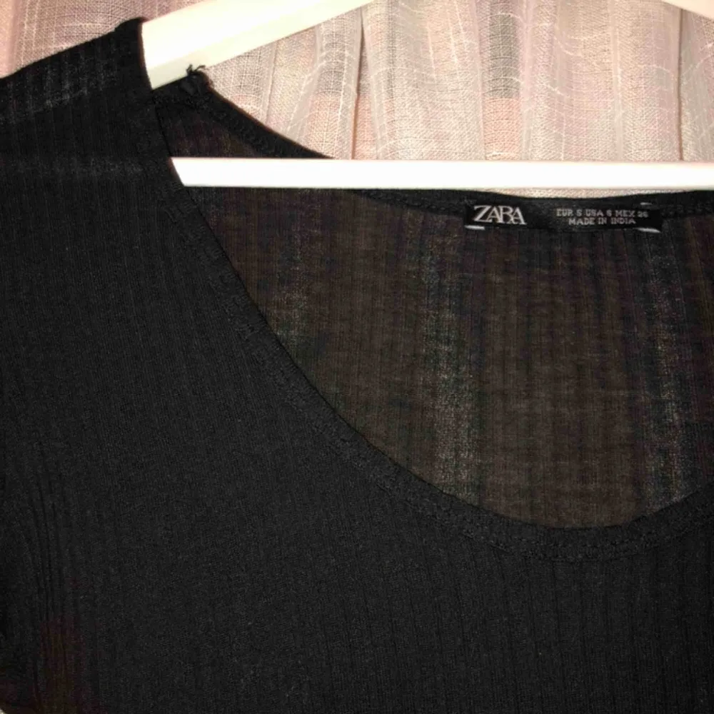 Fin, svart ribbad T-shirt från zara. Köptes i somras, endast använd 1 gång. Längre ärmar än på vanliga t-shirts. Fin passform, bra basplagg. Toppar.