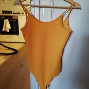  - Gul ribbad body. Hämtas i Årsta 