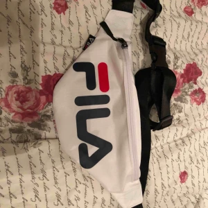  - En helt ny och oanvänd magväska från fila i vit, har ett fack bak och är hel vit med loggan på framsidan av väskan! 