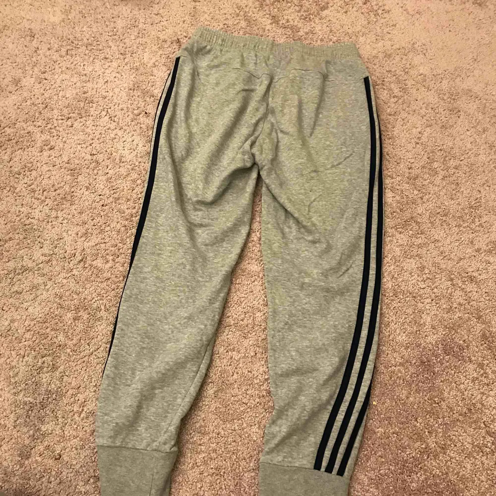Snygga Adidasbyxor som ej kommer till användning! Riktigt snygga. De vanliga traditionella tre blå strecken på sidan av benet. Använda 3 ggr. Köpta på Stadium för 449:- Frakt ca 54kr spårbar frakt 63kr. De är gråa & strecken marinblå. Möts upp i Göteborg. Farkut & Housut.