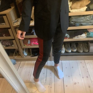 Läderbyxor från Zara - Läder byxor från Zara med röd rand. Säljer då de inte kommer till användning. Pris 100 sek exklusive frakt.