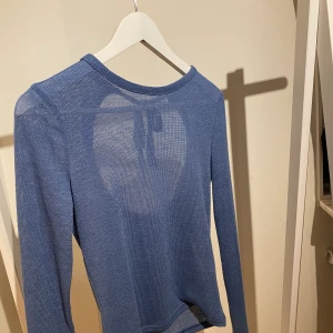 Topp - En blå topp med öppning i ryggen.