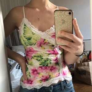 Blommigt y2k linne - Blommigt linne i vitt, grönt och rosa med spetsdetalj. Sjukt fint men kommer inte till användning för mig. Det är lite genomskinligt baktill men inte där fram. Kan mötas i Stockholm annars betalar köpare frakt <3