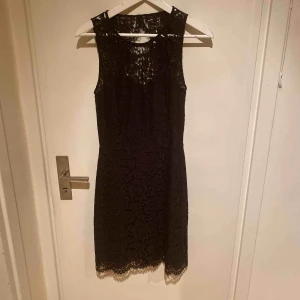  - Festklänning i svart spets med öppen rygg. Använd vid ett tillfälle. 