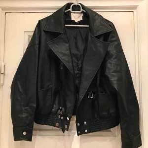  - Svart "skinn"-jacka i PU-material i oversize modell (alltså ej äkta skinn!) Använd ca 3 ggr så i mycket fint skick och inget att anmärka på! Nypris: 999kr Finns att hämta i Hornstull, eller skickas mot frakt!
