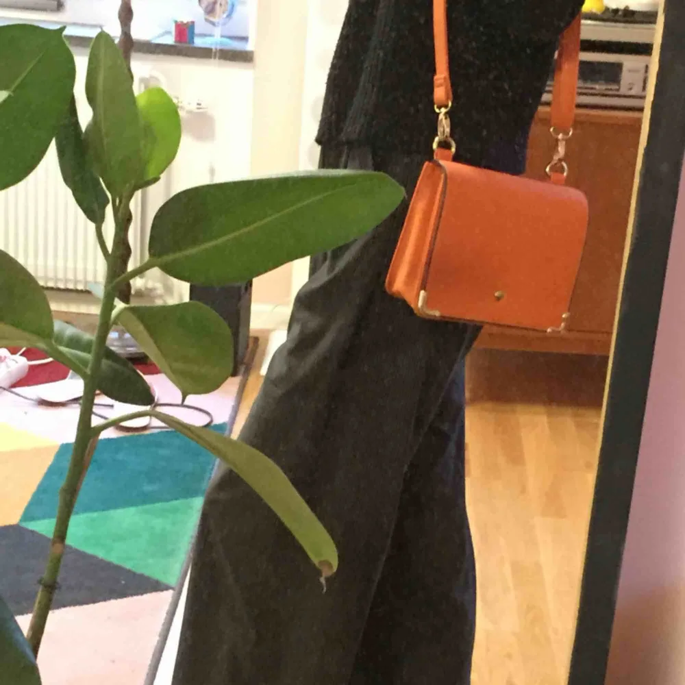 Snygg orange handväska, liten men lagom (rymmer tex cigaretter, telefon och en pocketbok!) retrokänsla och fin färg! Som ny, köpt här men inte kommit till användning 😥🧡🧡🧡. Väskor.