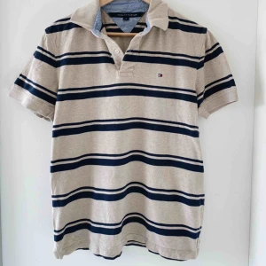 Tommy Pike - En beige/blå vintage/retro topp från  Tommy Hilfiger! Knappt använt, jätte fint skick :) Kan så klart skicka fler bilder, och frakt tillkommer! Står M men är mer one size ☺️