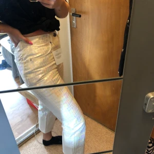 Regnbågsbyxor från ASOS - Så jävla fina jeans med regnbågsskimmer i mönster från ASOS! Aldrig använda, fick hem dem precis men de är lite för små, så säljer därför vidare. Storlek 26/28, men värt att tänka på att det är nästintill ingen stretch över rumpan💛frakt på 50 tillkommer!