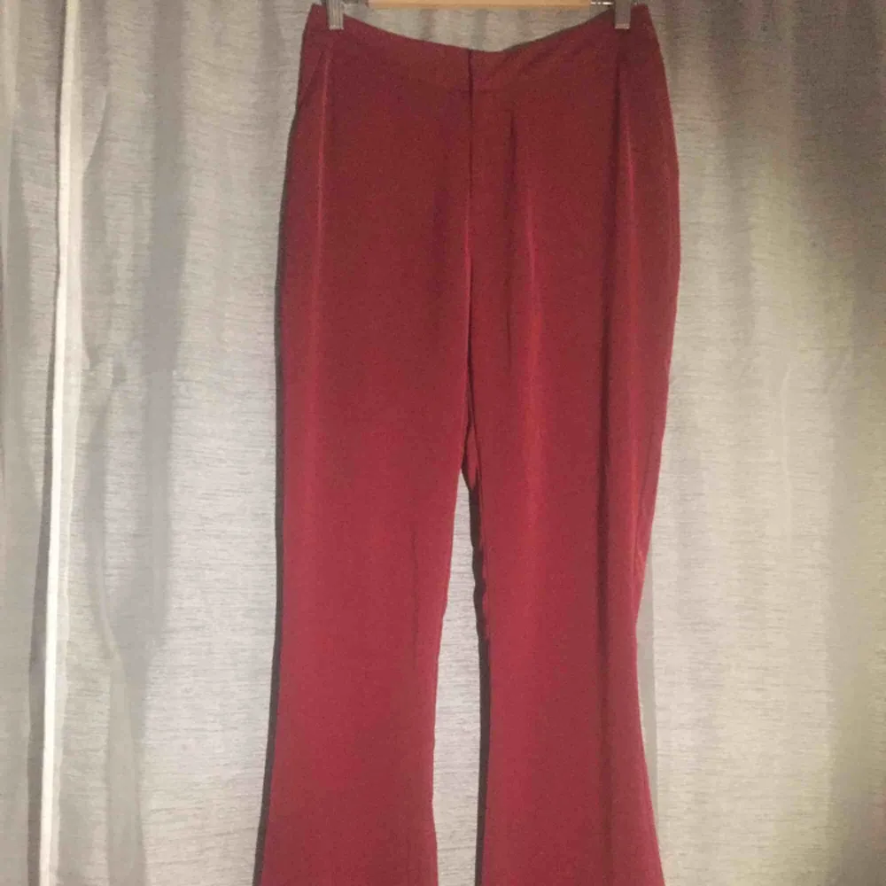 Röda finare byxor med fickor fram, rena bak, något utsvängda. Passar M-L (mindre L). Jeans & Byxor.
