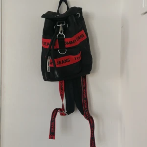 Tommy hilfiger backpack black - Backpack in black with red logo. Bought in USA. Barely used. Length 27cm height 30cm width 10cm.in perfect condition 