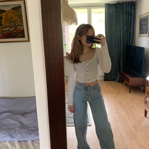 Vit ribbad topp - Vit tröja med grå-marmorerade knappar, toppskick! 🥰 Croppad och långärmad. Storlek S men med mycket stretch, skulle säga att den passar även den som har XS. 