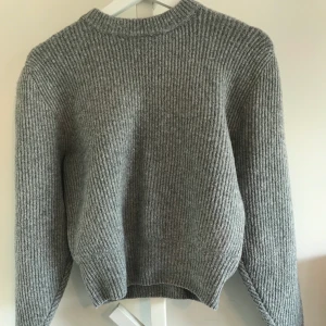 Stickad tjocktröja från &Other Stories - Jättefin Grå stickad tjocktröja med puffärmar från & Other Stories. Frakten betalas av köparen och ligger på ca 40kr.